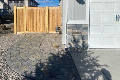 Paver sidewalk leading from the back of the house through the fence and to the front of the house by Palominos Landscaping of Caldwell Idaho